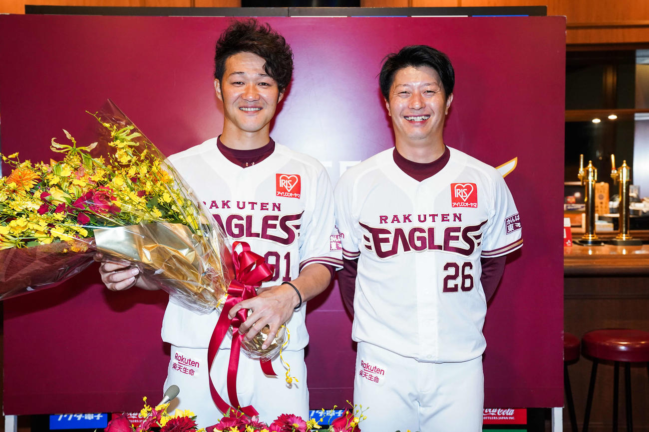 引退会見に臨んだ楽天久保（左）は花束を贈呈した渡辺直内野手兼任打撃コーチ（右）と笑顔で記念撮影（球団提供）