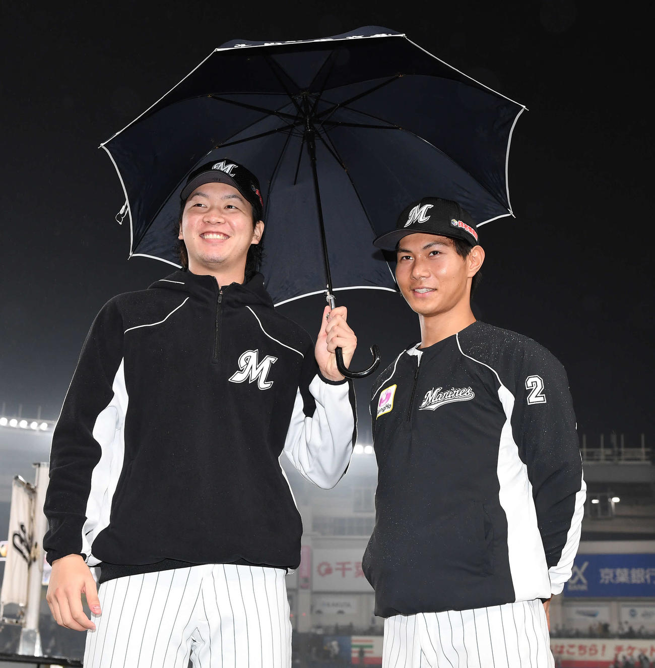 ロッテ対オリックス　オリックスに勝利し、相合い傘で笑顔を見せるロッテ藤原（右）と二木（撮影・鈴木みどり）