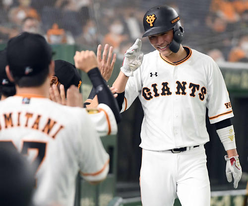 巨人対ヤクルト 1回裏巨人2死二塁、岡本和真の中前安打で生還した坂本勇人は、ナインと祝福に笑顔を見せる(撮影・たえ見朱実)