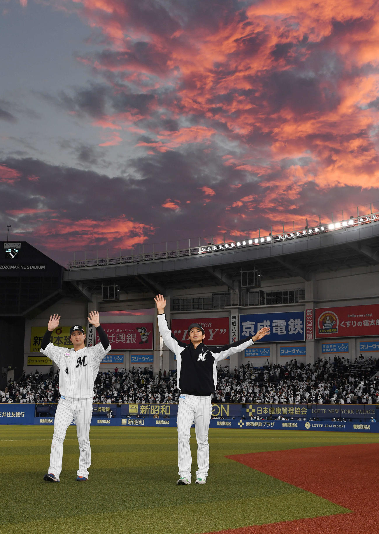 ロッテ対西武　西武に勝利しCS進出を決めファンの声援に応えるロッテ藤岡（左）と唐川（撮影・鈴木みどり）