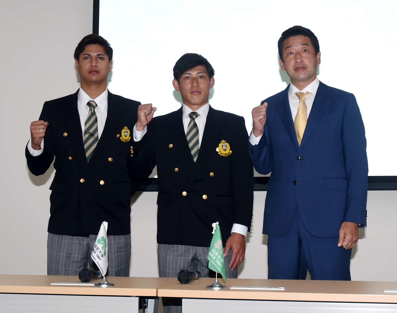 指名あいさつ後にガッツポーズをする左から仙台大・宇田川、佐野、オリックス佐藤スカウト（撮影・相沢孔志）