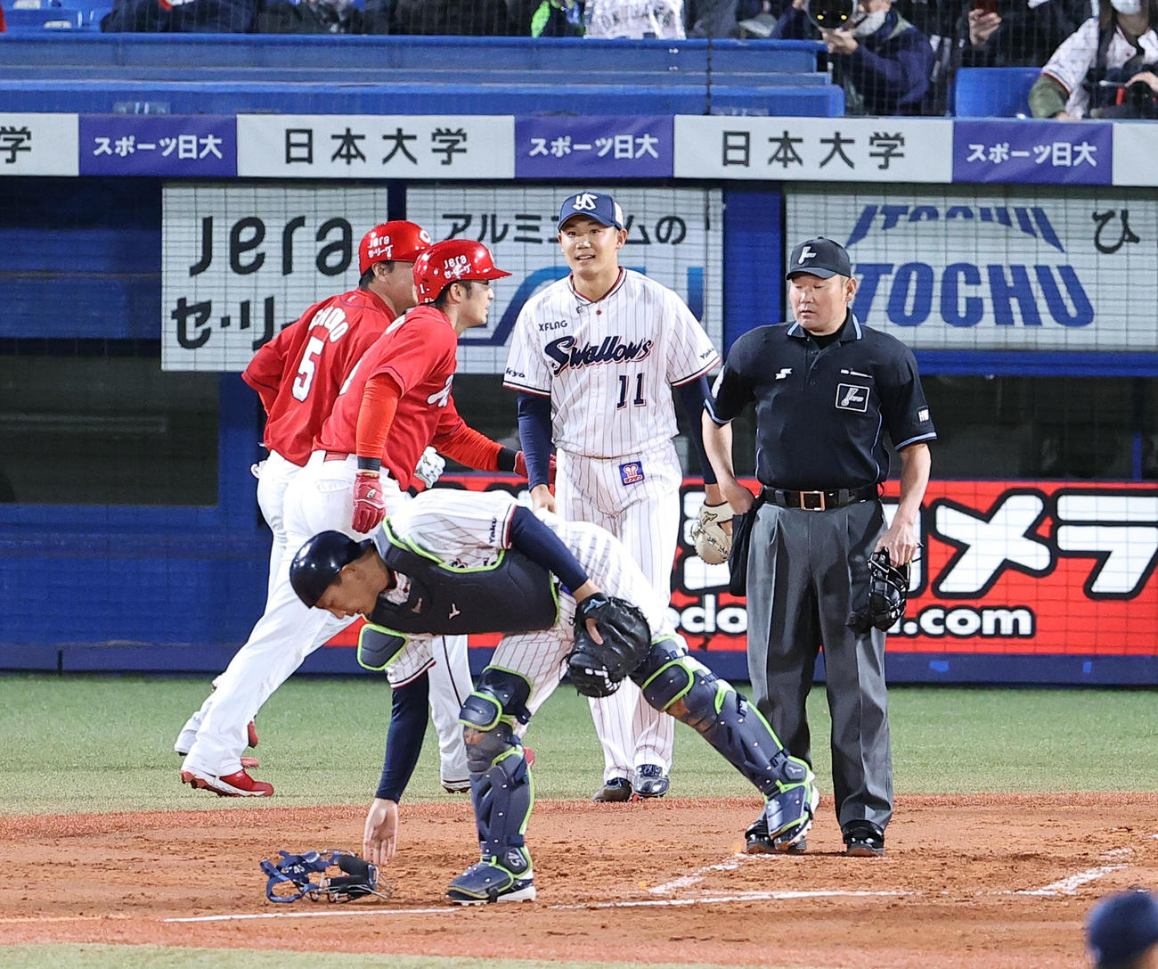 ヤクルト対広島　1回表広島1死一、三塁、松山に左2点適時二塁打を許し、生還した鈴木誠（左から2人目）、長野（左）の奥で苦笑する奥川（撮影・浅見桂子）