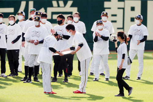 阪神対巨人　練習前、梅野隆太郎（左）から記念ボードを手渡される藤川球児（撮影・加藤哉）
