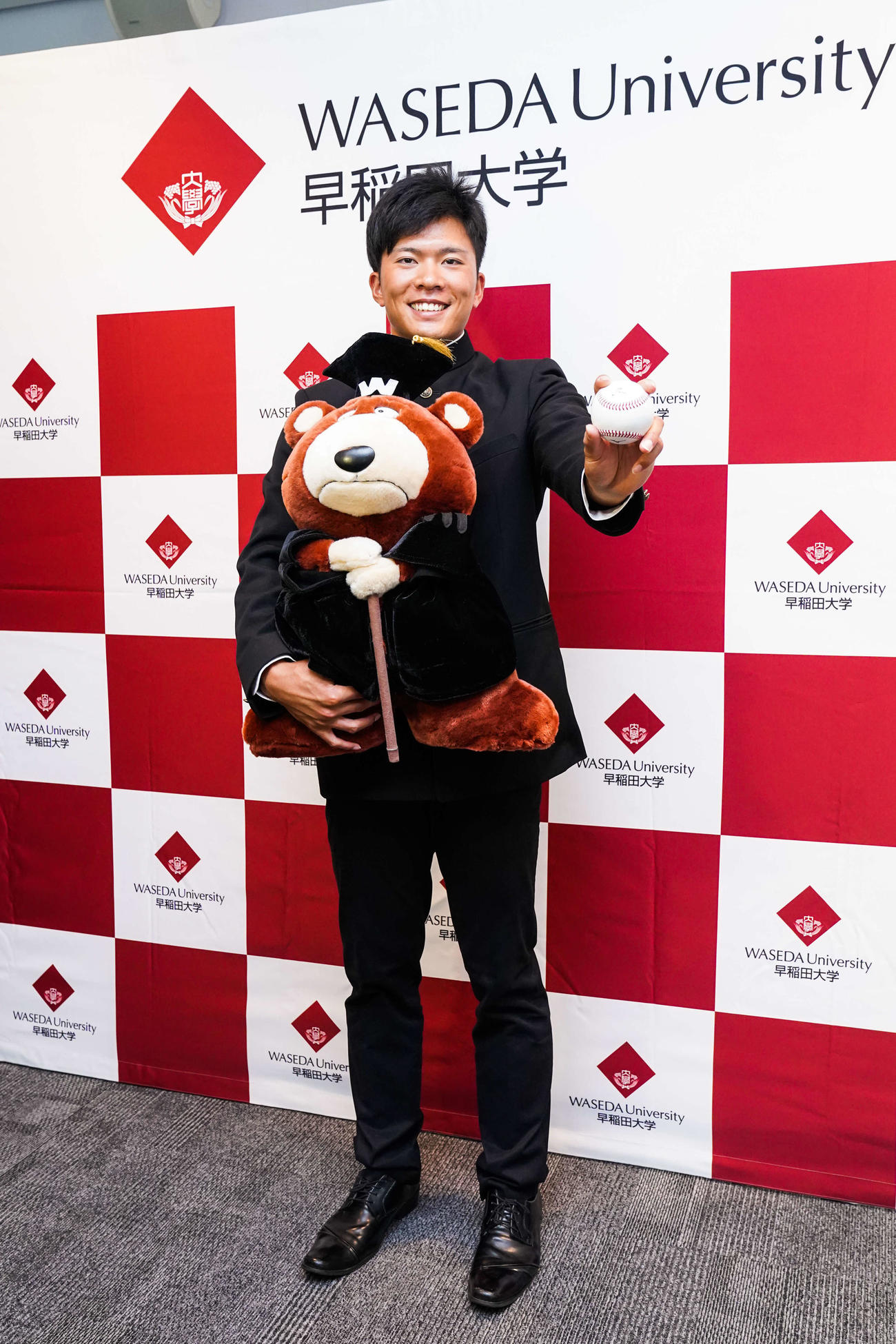 指名あいさつを受けた楽天ドラフト1位指名の早大・早川はボールを握り笑顔を見せる（球団提供）
