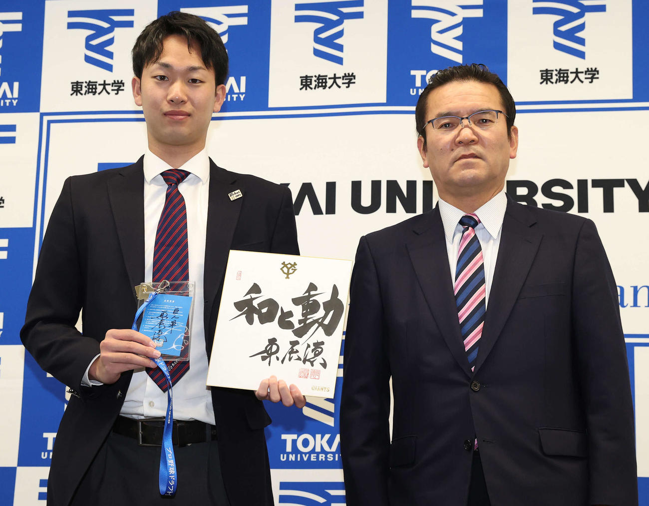 巨人ドラフト2位指名のあいさつを受け記念撮影に納まる東海大・山崎（左）と巨人大塚副代表（撮影・河野匠）
