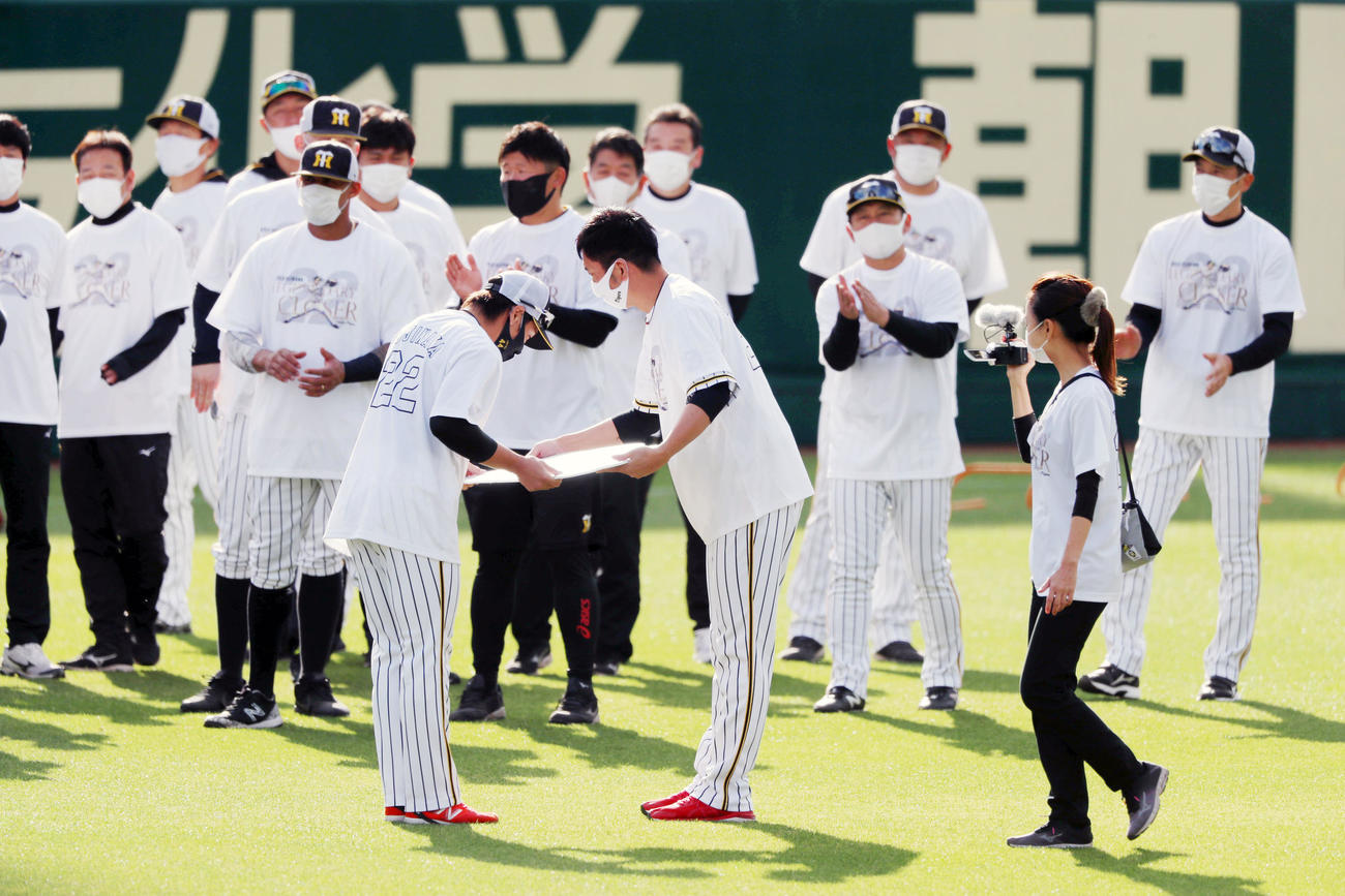 阪神対巨人　練習前、梅野（左）から記念ボードを手渡される藤川（撮影・加藤哉）