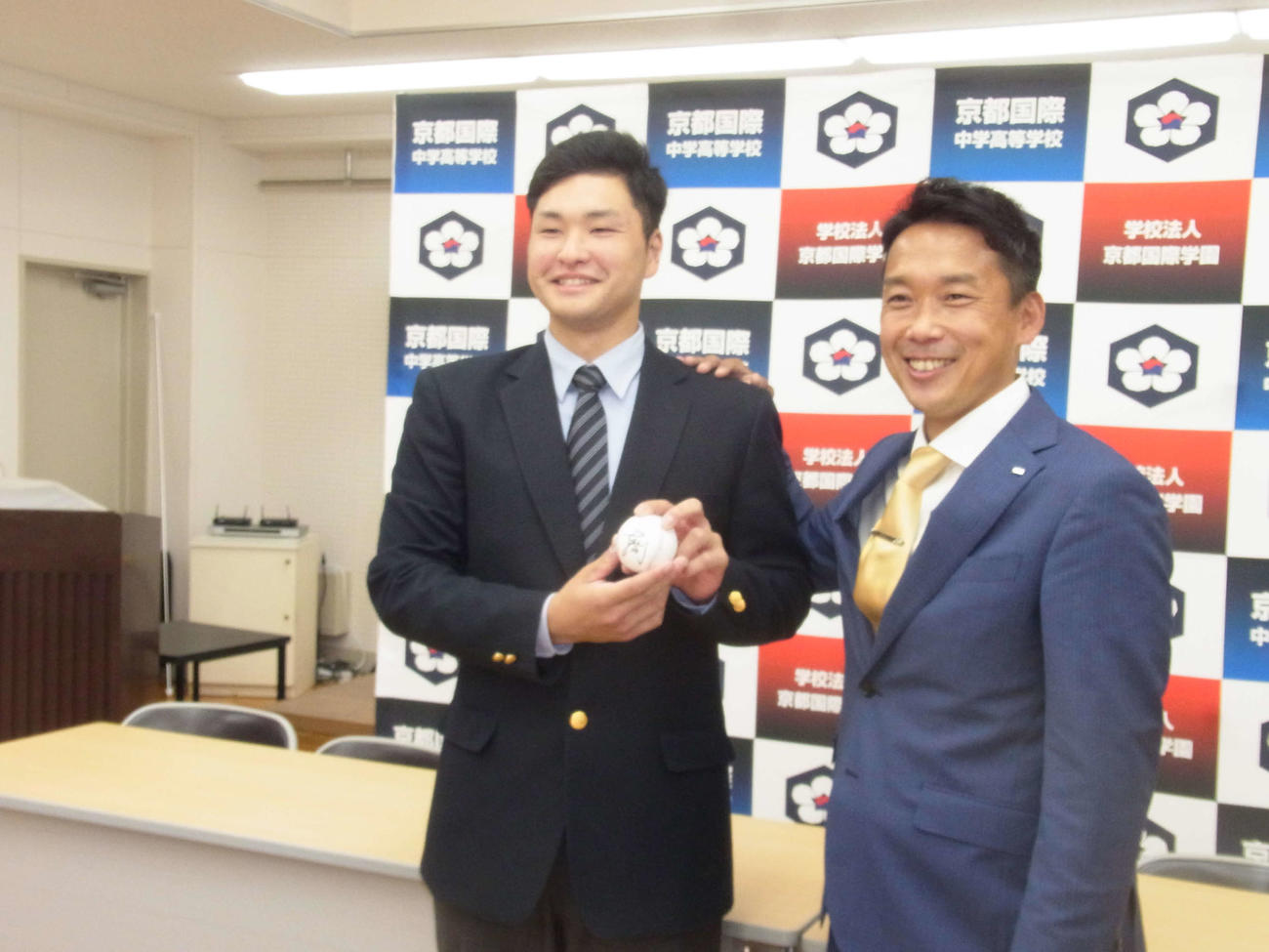 オリックス育成4位の京都国際・釣（左）は担当の下山スカウトから、中嶋監督代行のサイン入りボールを贈られる（撮影・堀まどか）