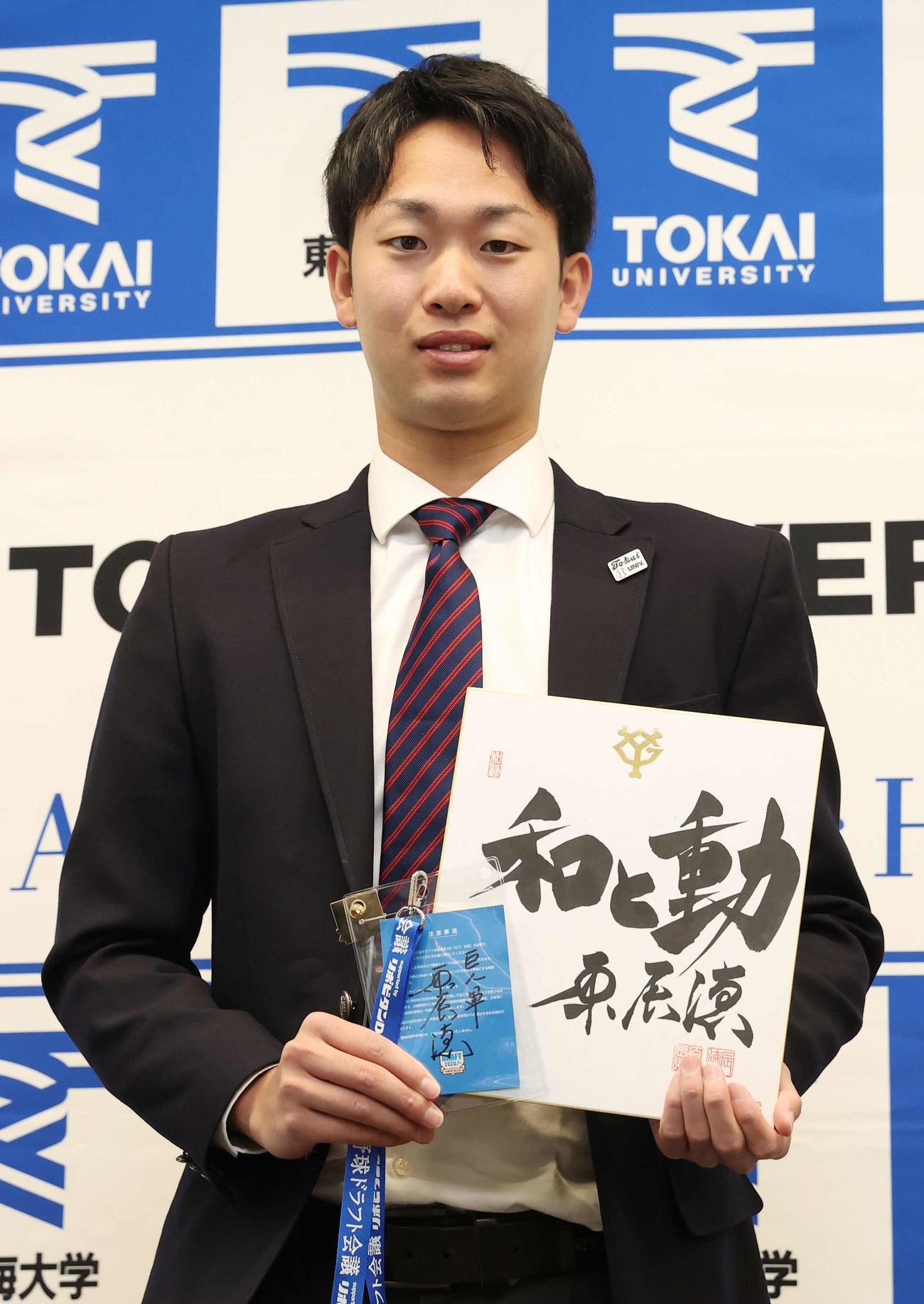 巨人ドラフト2位指名のあいさつを受けた東海大・山崎は巨人原監督の色紙とドラフト会議IDを手に記念撮影に納まる（撮影・河野匠）