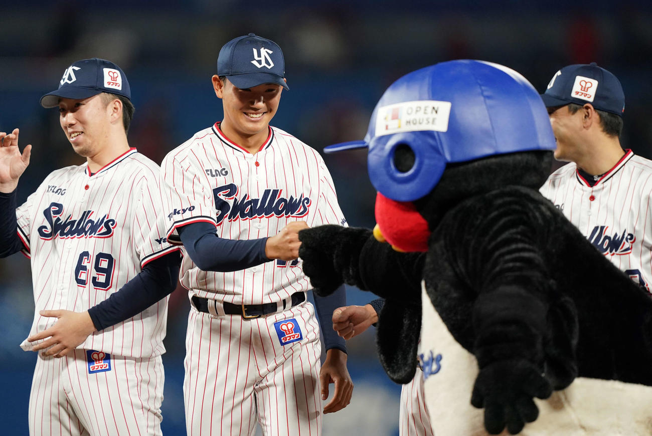 最終戦セレモニーで高津監督に急に呼ばれあいさつしたヤクルト奥川（左から2人目）は、列に戻りつば九郎とグータッチ（撮影・鈴木みどり）
