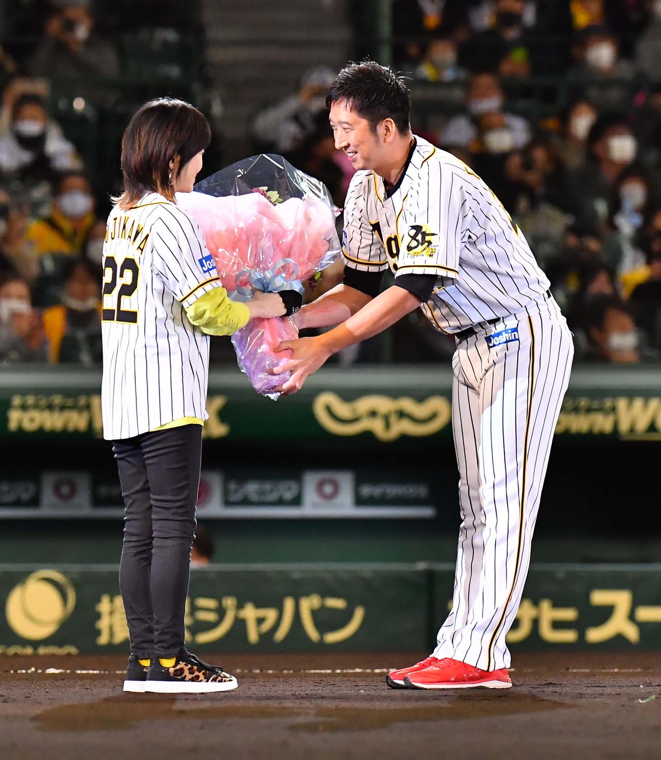 阪神対巨人　引退セレモニーで登場曲を歌う渡瀬マキから花束を受け取る藤川球児（撮影・上田博志）