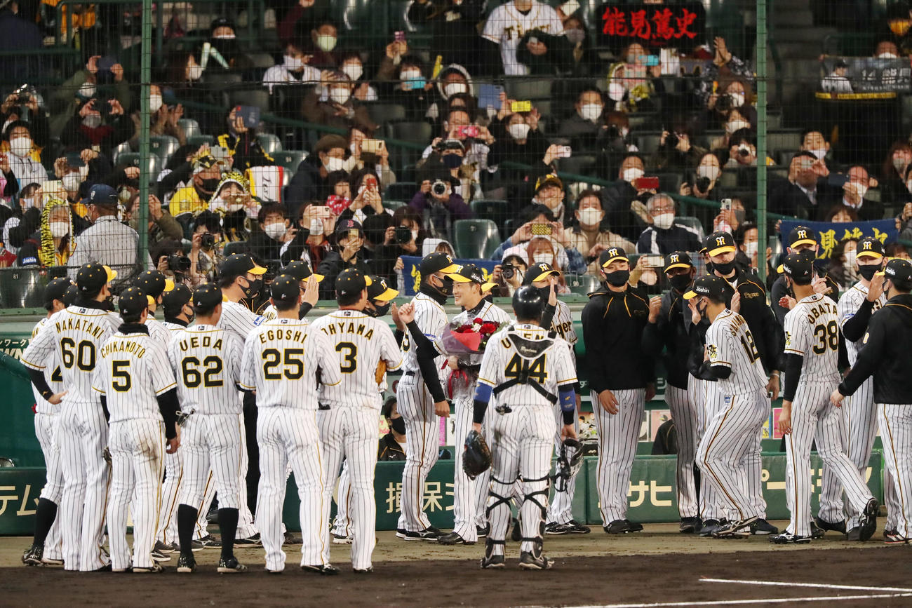 今季限りで退団する能見は花束を手にナインとエアタッチする（撮影・加藤哉）