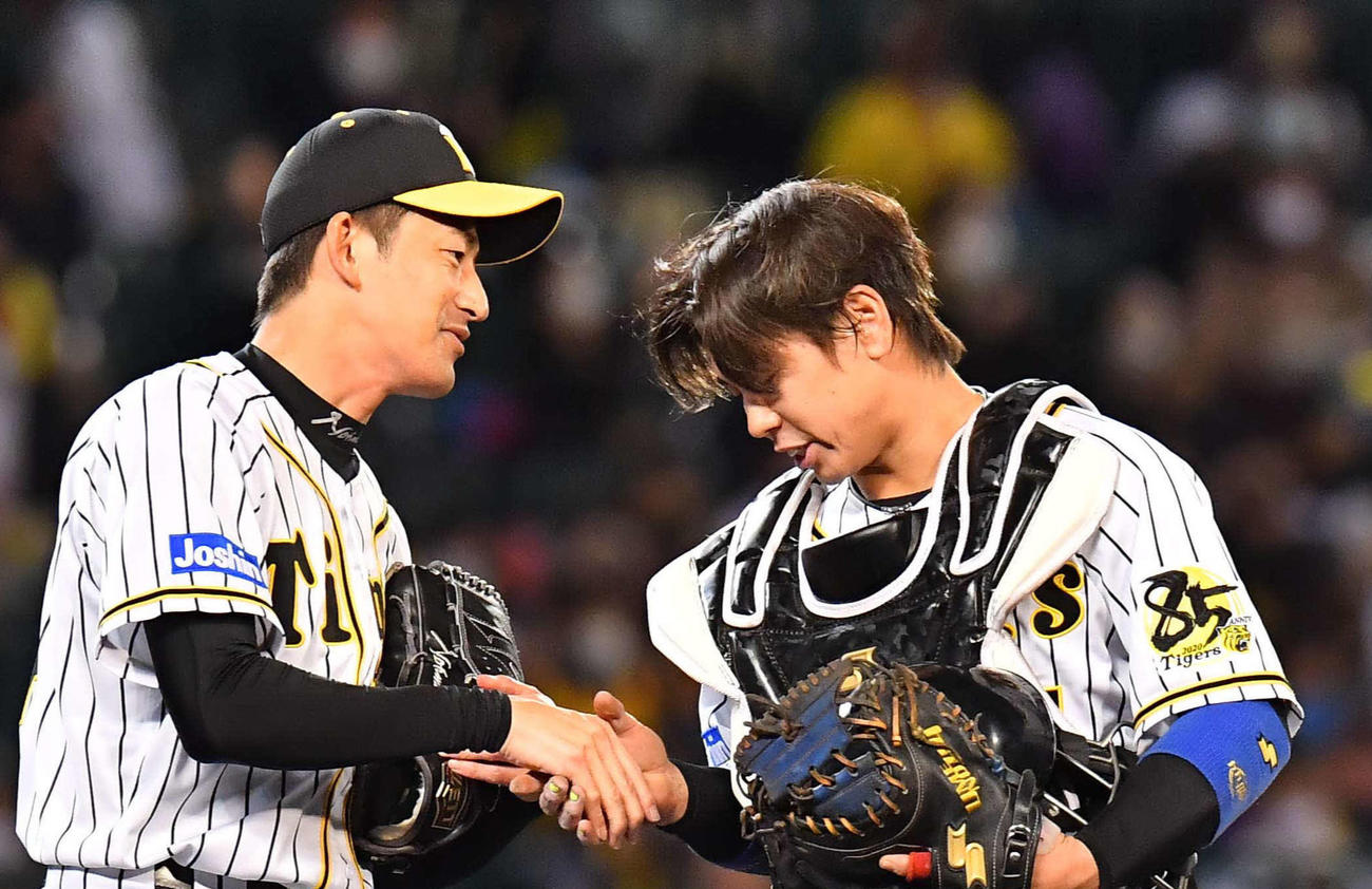 阪神対DeNA　タイガース最後の投球を終え梅野（右）と握手を交わす能見（撮影・上田博志）