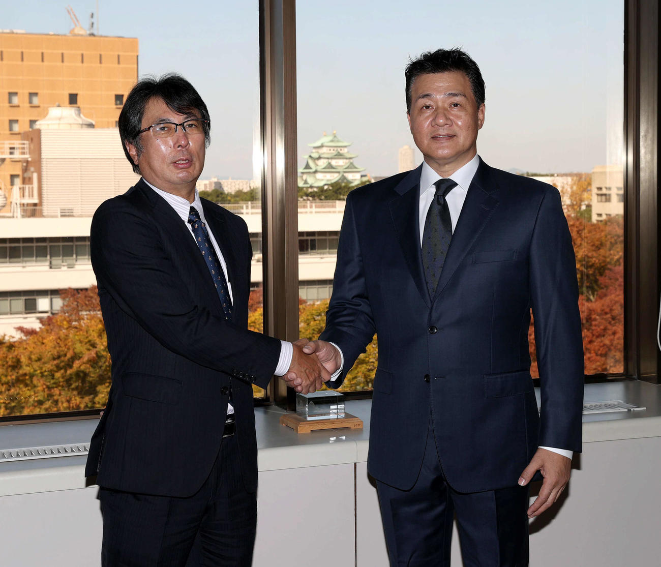 今シーズンの日程が終了し、大島オーナー（左）へ報告に訪れ握手を交わす与田監督
