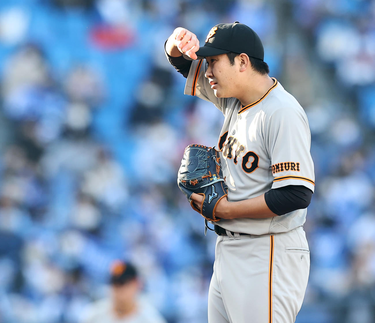 DeNA対巨人　5回裏DeNA無死、投球前、西日から手で顔をかざしサインを確認する菅野（撮影・浅見桂子）