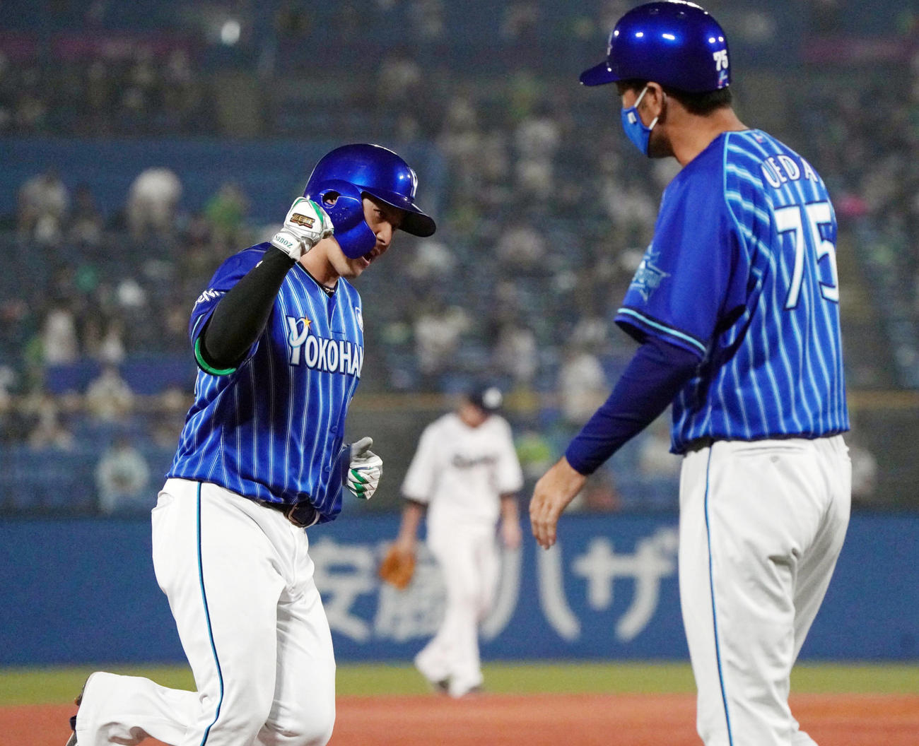 本塁打を放った佐野を迎えるDeNA上田コーチ（右＝8月8日撮影）