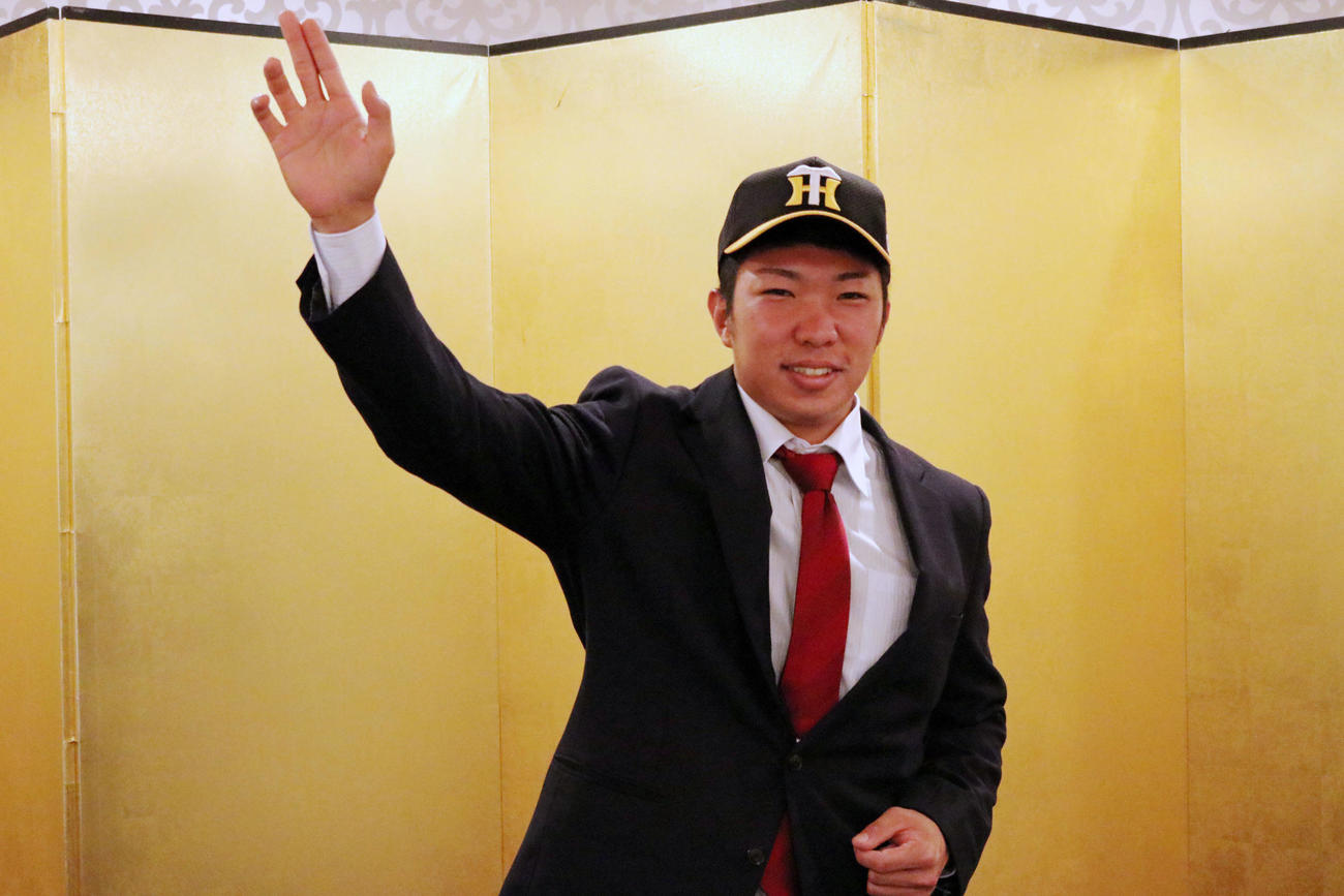 高知市内のホテルで阪神と仮契約を行った石井大はシャドーピッチングを披露する（阪神球団提供）