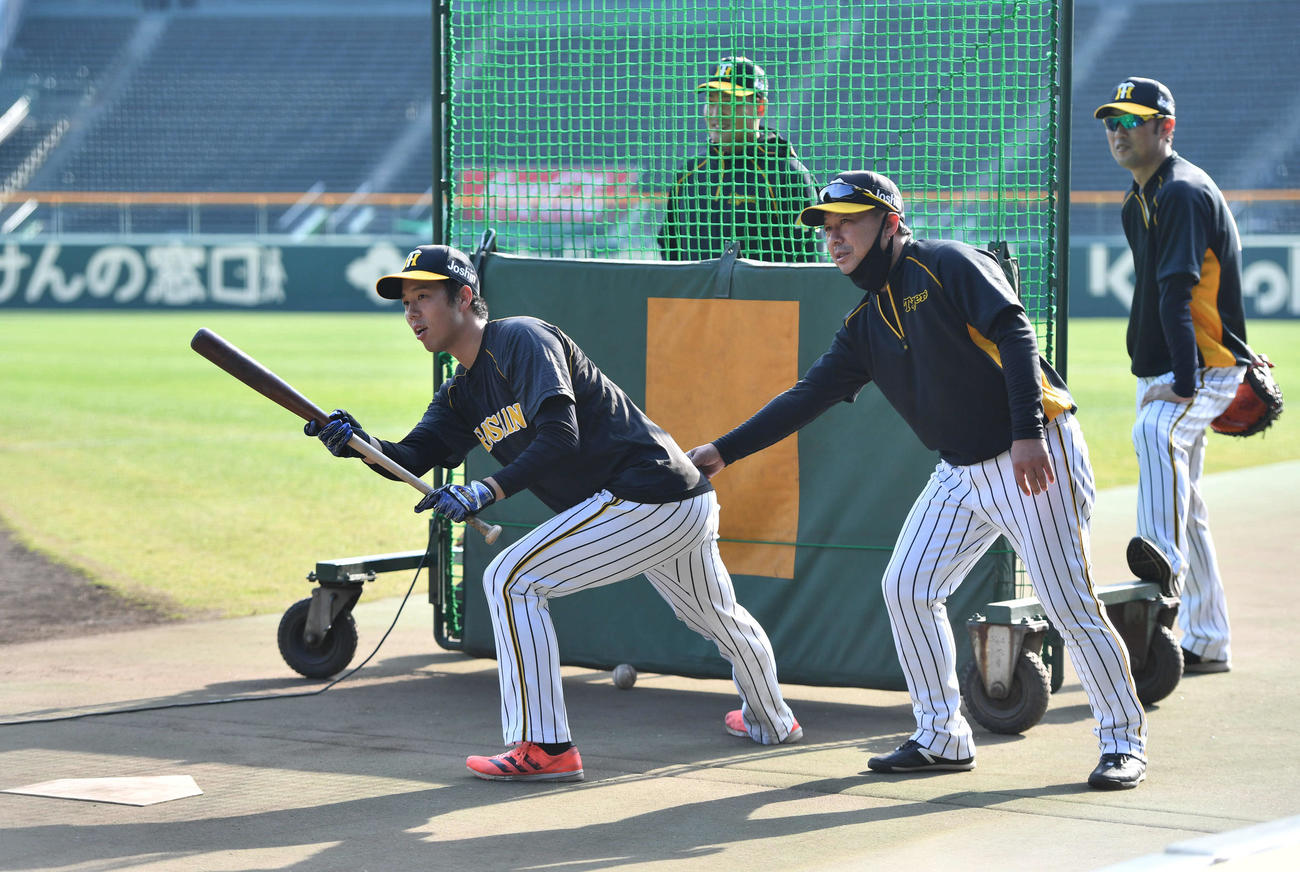 青柳（左）にバントの指導を行う久慈内野守備兼バントコーチ、後方左は秋山、右は金村投手コーチ（撮影・岩下翔太）