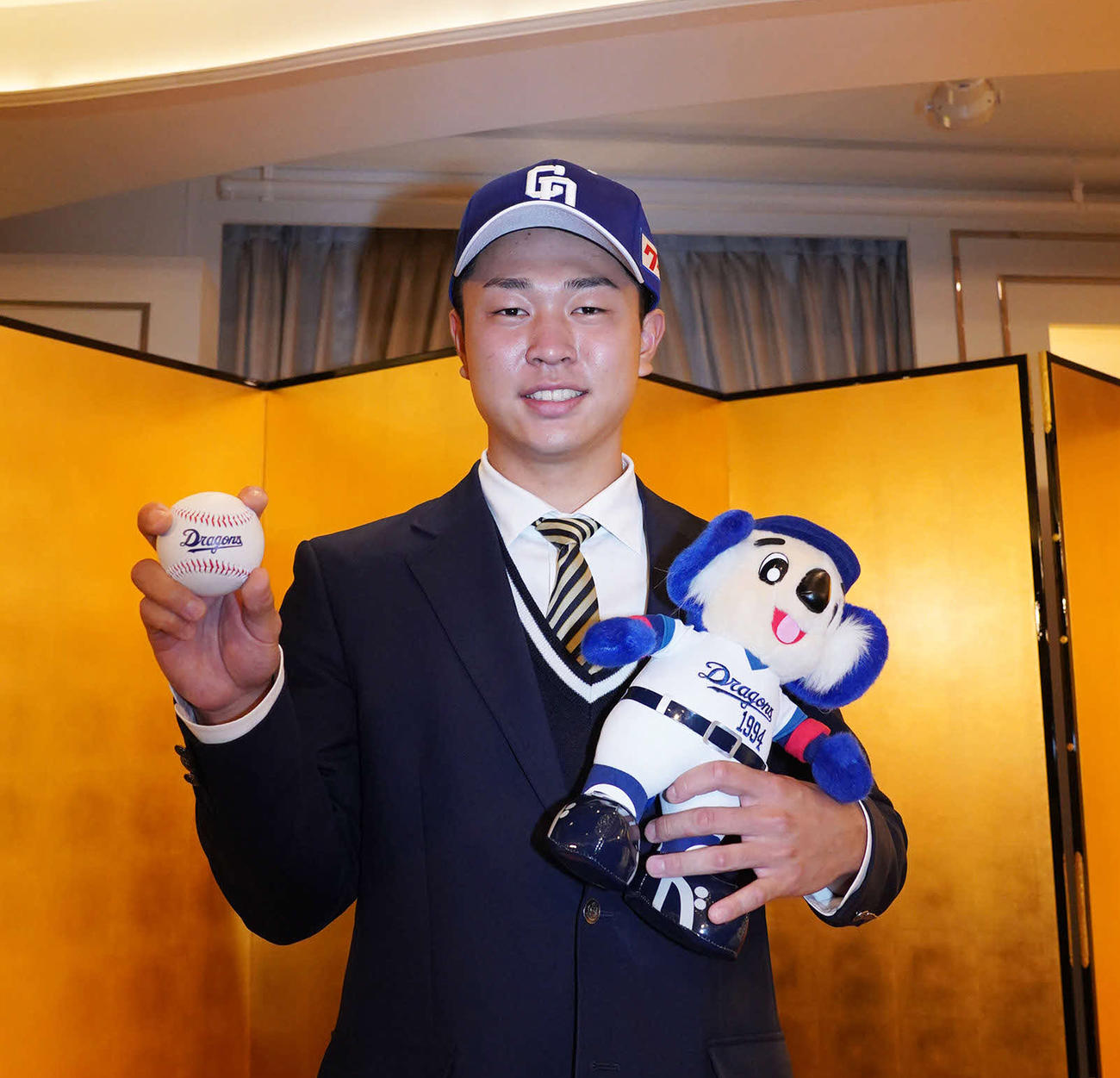 仮契約を終えた、中日ドラフト1位高橋はドアラを抱えポーズを決める（撮影・森本幸一）