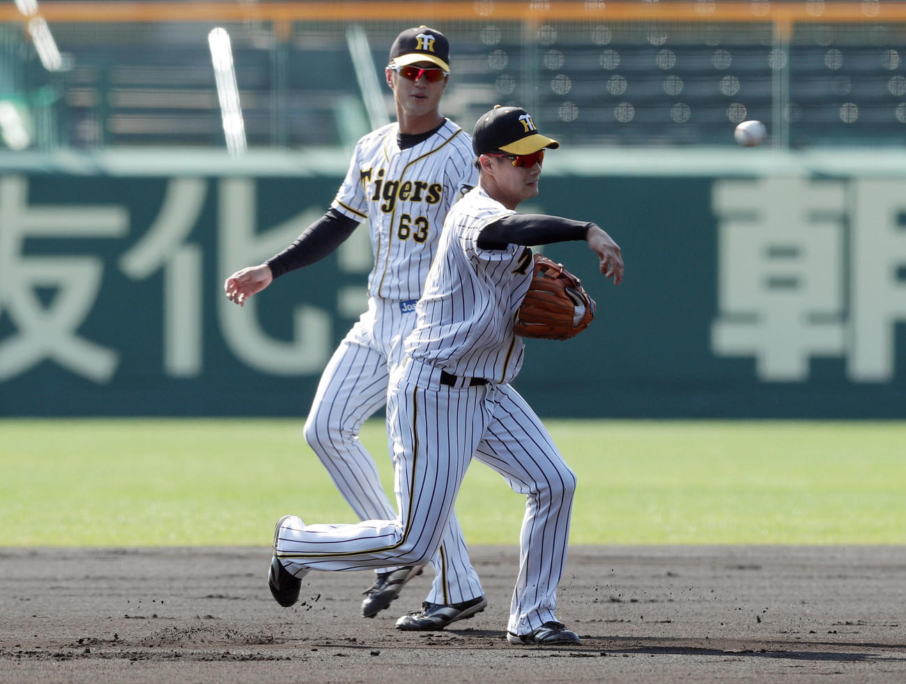 投内連係を行う阪神木浪。後方は板山（撮影・前田充）