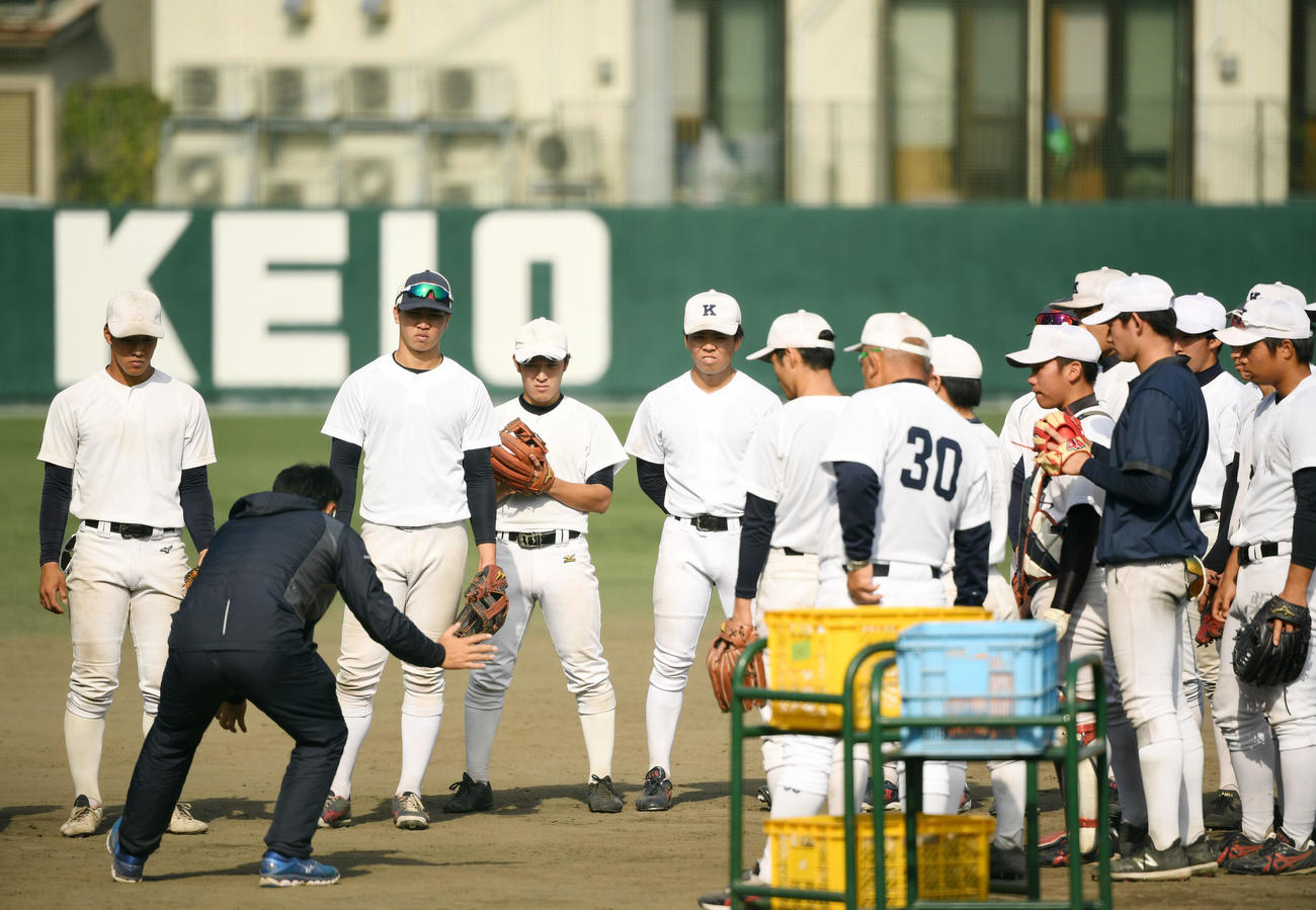 真剣な表情で宮本慎也氏のアドバイスを聞く慶大ナイン（撮影・横山健太）