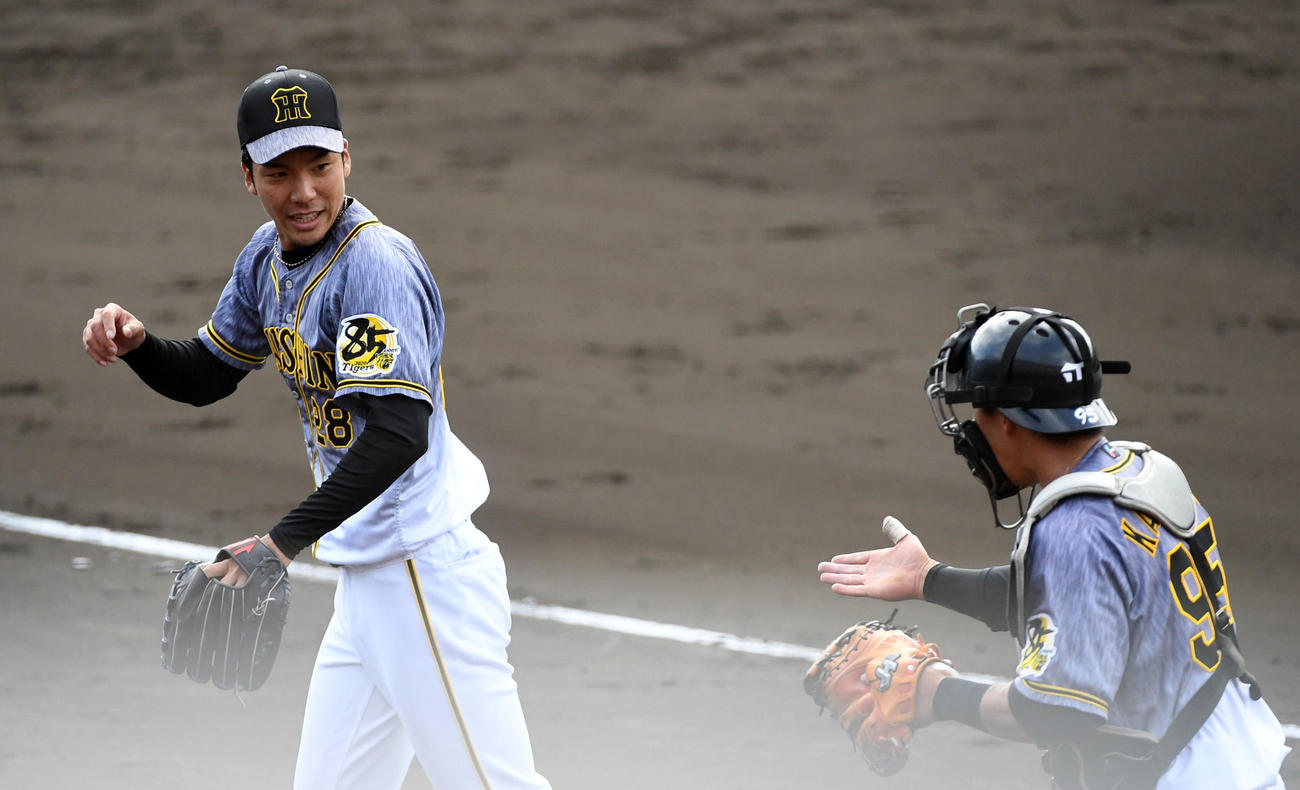 ヤクルト対阪神　5回、ベンチに戻る小野（左）は片山から祝福を受ける（撮影・前岡正明）