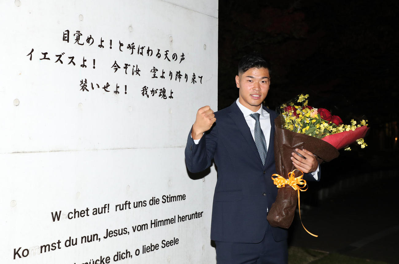 母校仁川学院のモニュメントの前でポーズを決める阪神ドラフト1位指名の佐藤（撮影・加藤哉）