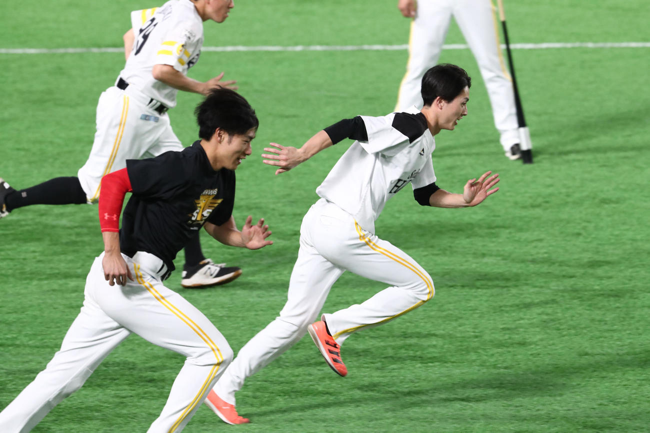 練習前、軽めのダッシュをする周東佑京、手前は柳田悠岐（撮影・梅根麻紀）