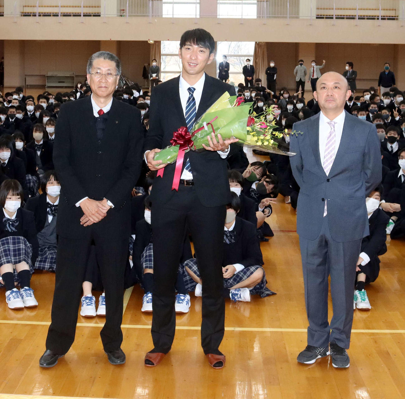 白樺学園の後輩たちに祝ってもらい笑顔の星槎道都大・河村投手（中央）。左は白樺学園の嶋野校長、右は同戸出監督（撮影・永野高輔）