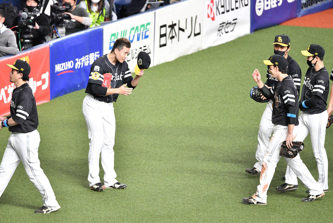 巨人対ソフトバンク　5回裏巨人2死一塁、吉川尚の右飛を捕球した栗原（右）を帽子を取って迎える千賀（撮影・岩下翔太）