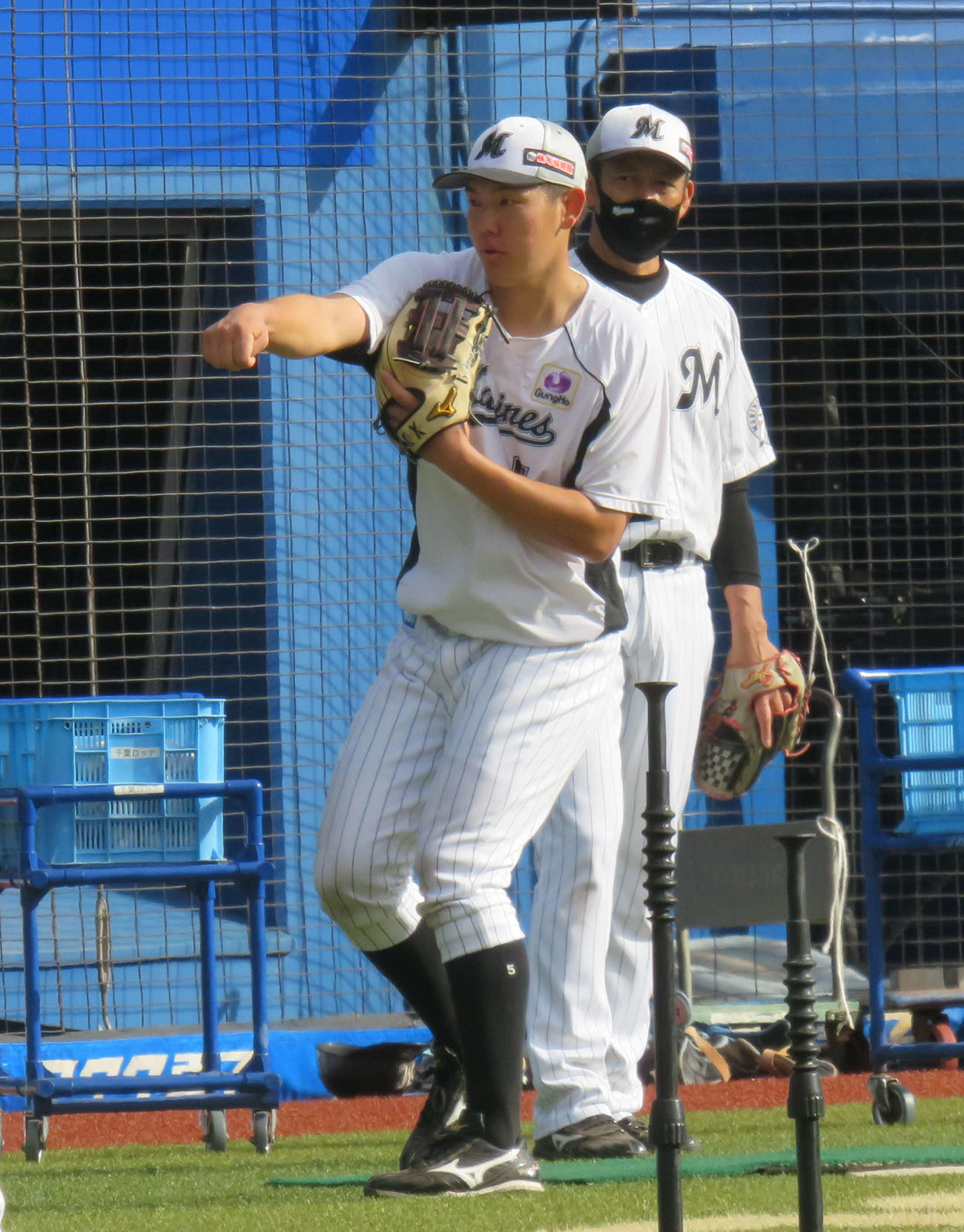 鳥越ヘッドコーチ（右）とマンツーマンで特守を行うロッテ安田