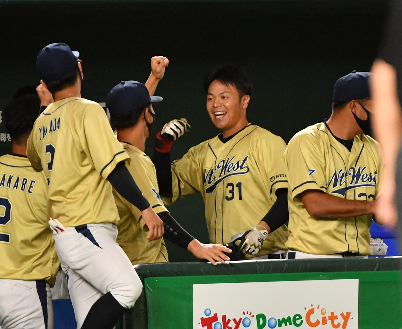 東芝対NTT西日本　4回裏NTT西日本無死、西川（右から2人目）は左中間に本塁打を放ちナインとハイタッチする（撮影・柴田隆二）