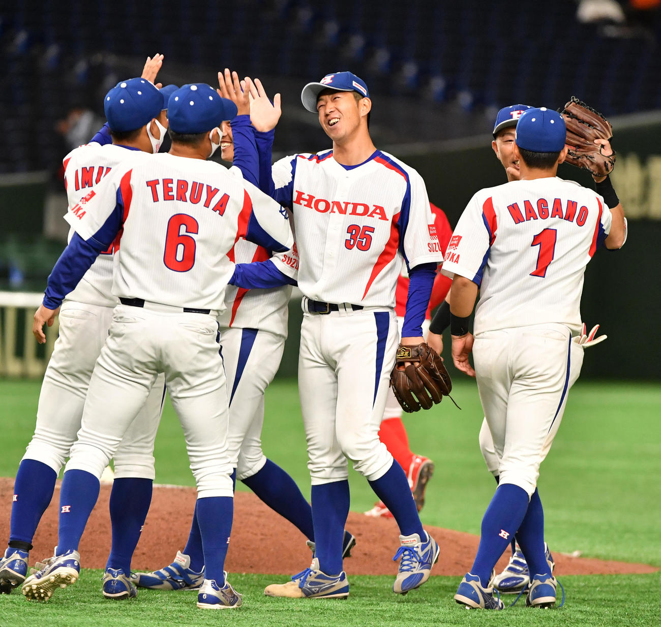 日本生命対ホンダ鈴鹿　勝利したホンダ鈴鹿・堀田（中央）はナインと喜び合う（撮影・柴田隆二）