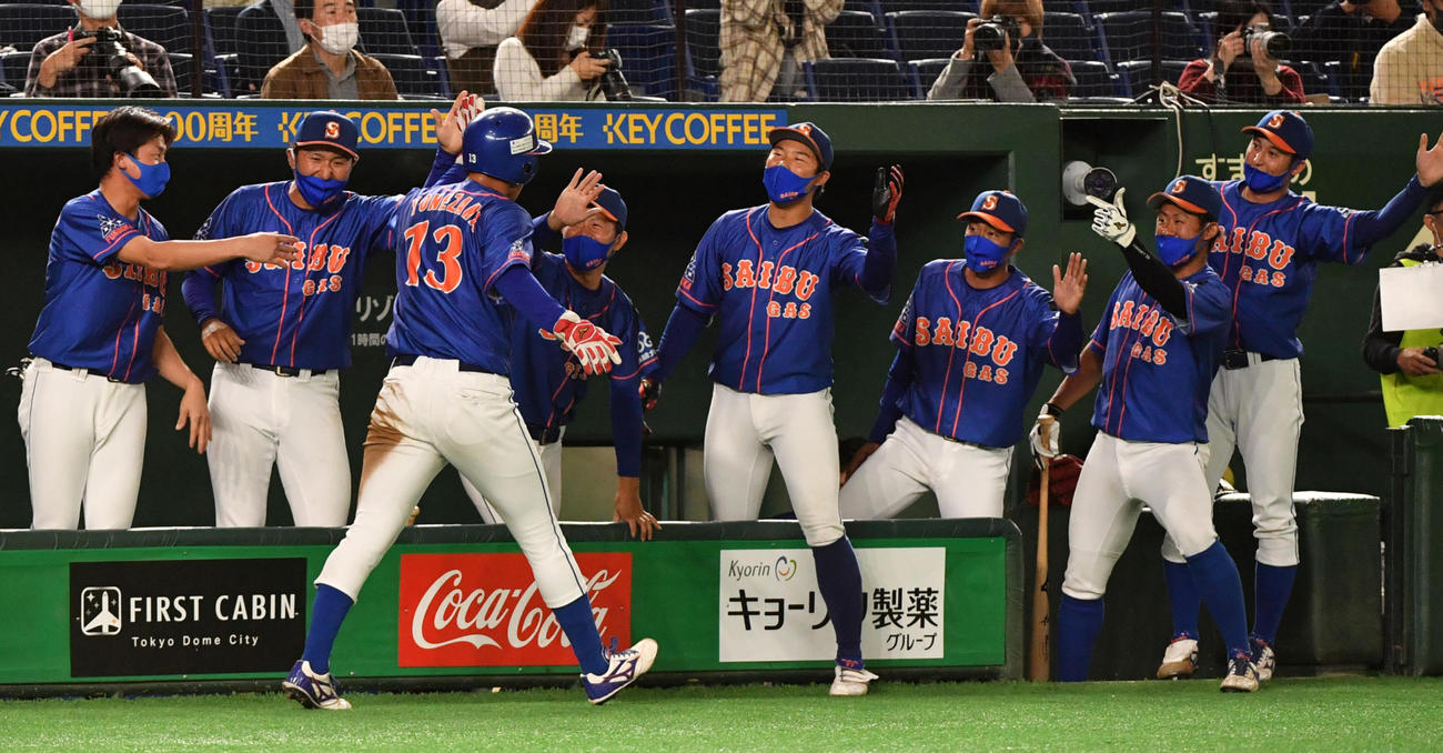 日本製紙石巻対西部ガス　7回裏西部ガス1死一、二塁、山中の左前適時打で二塁走者米沢が生還しナインの出迎えを受ける（撮影・柴田隆二）