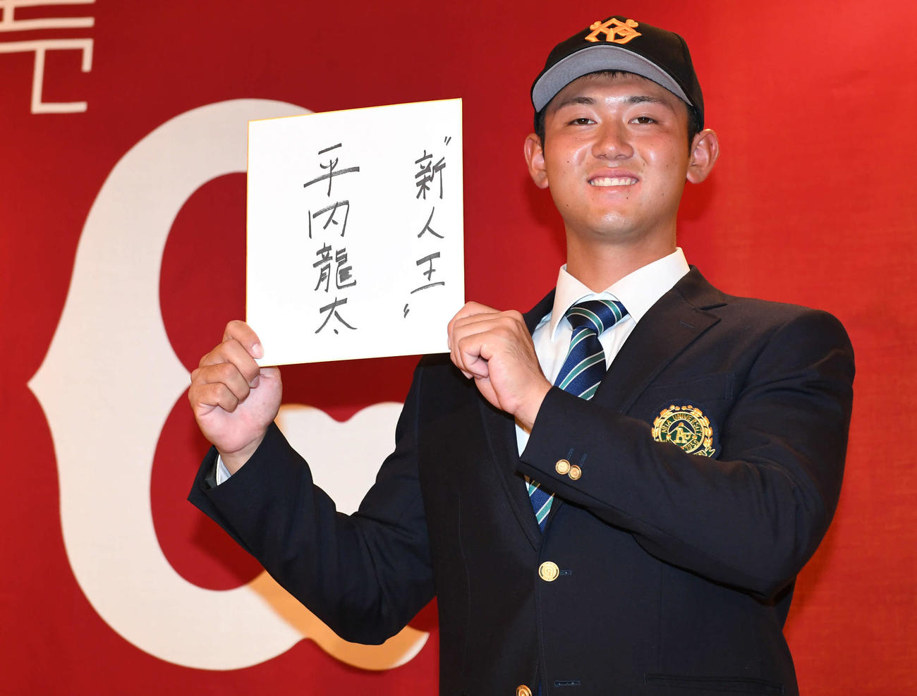 仮契約を終えた巨人ドラフト1位平内は「新人王」と目標を書いた色紙を手に笑顔（撮影・山崎安昭）