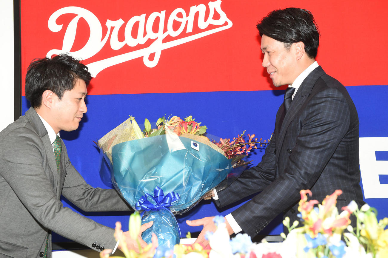 沢村賞に選ばれ報道陣代表からお祝いの花束を受け取る大野雄（撮影・前岡正明）