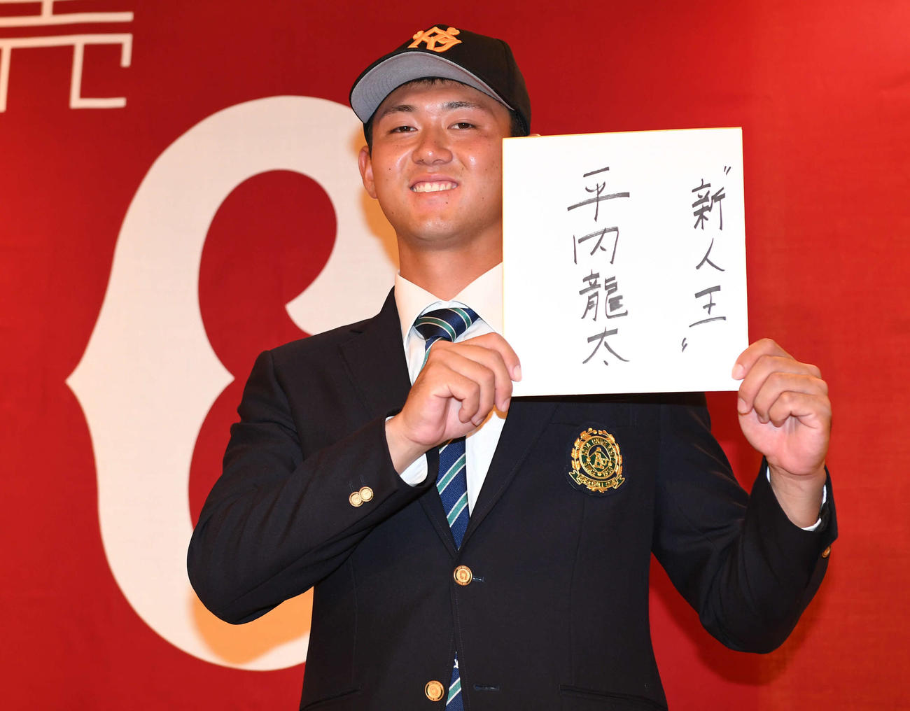 仮契約を終えた巨人ドラフト1位平内は「新人王」と目標を書いた色紙を手に笑顔（撮影・山崎安昭）