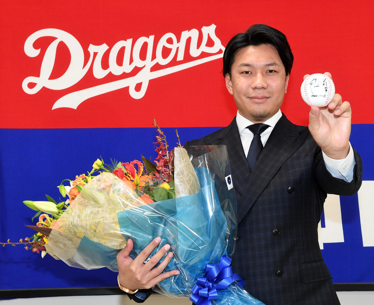 沢村賞としたためたボールと花束を手に喜びの表情を見せる大野雄（撮影・前岡正明）