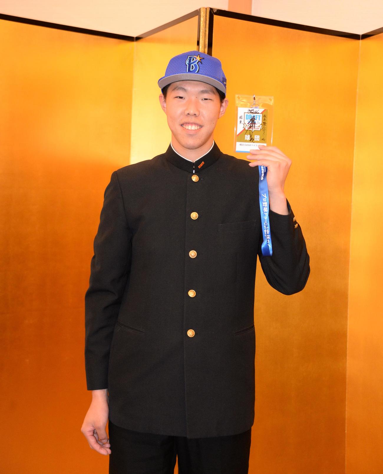 仮契約を終えたDeNAドラフト3位の横浜・松本は、三浦監督のサイン入りドラフト会議入場証を手に笑顔を見せる（撮影・鈴木正章）