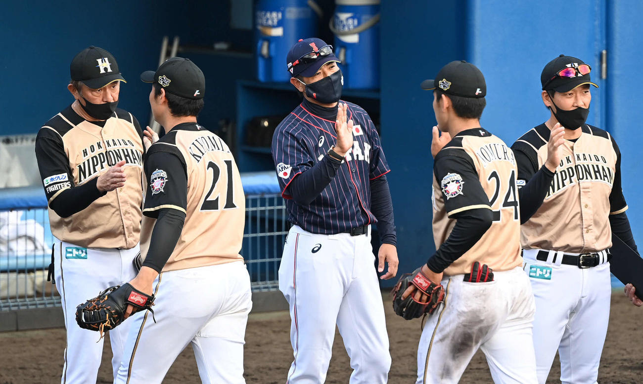 西武対日本ハム　侍ジャパン稲葉監督（中央）は試合後、引き揚げる日本ハムの選手を出迎える。左は荒木2軍監督（撮影・山崎安昭）