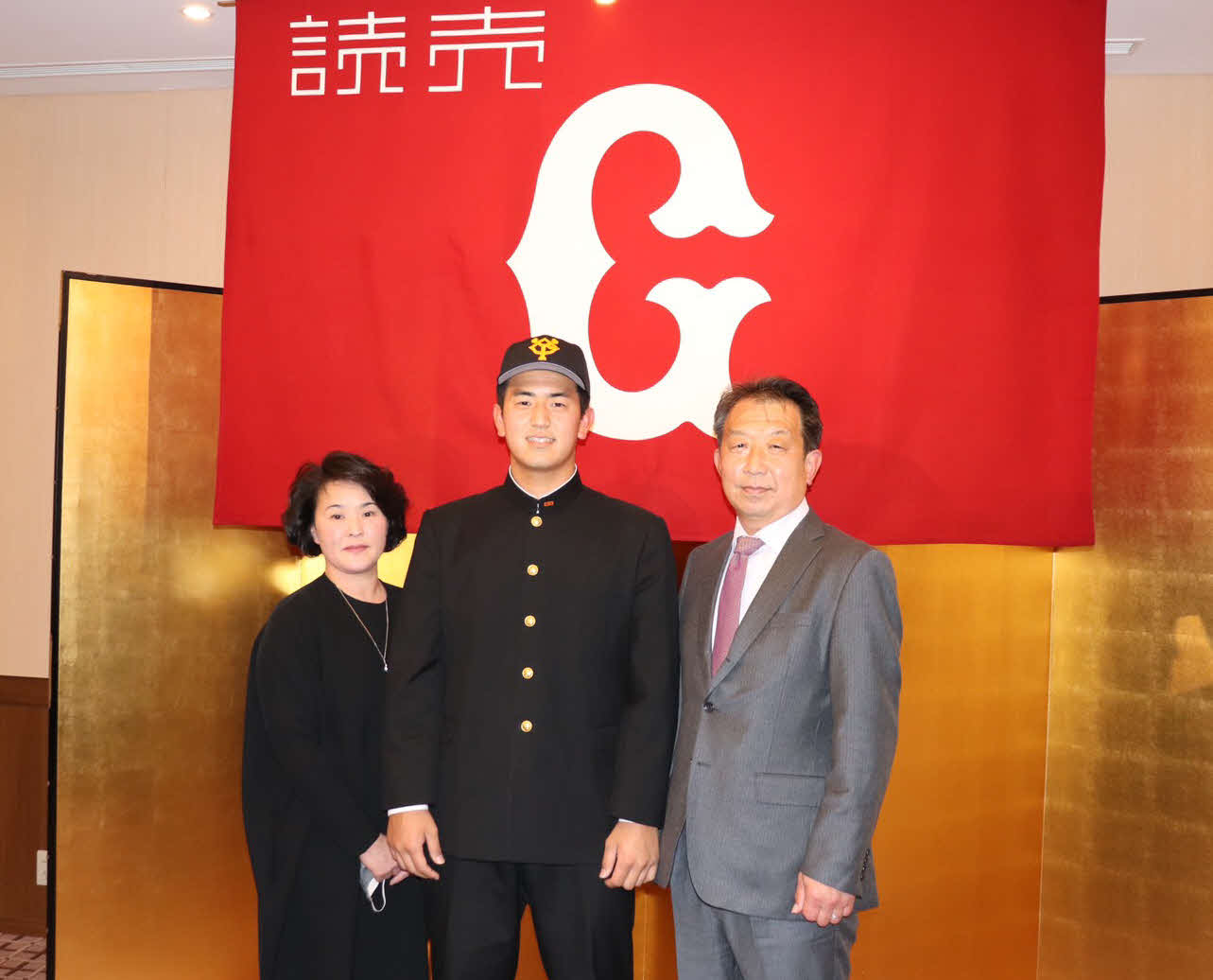 仮契約を結び、笑顔を見せる巨人育成4位の横浜・木下（中央）。右は父道夫さん左は母由か里さん（撮影・久永壮真）