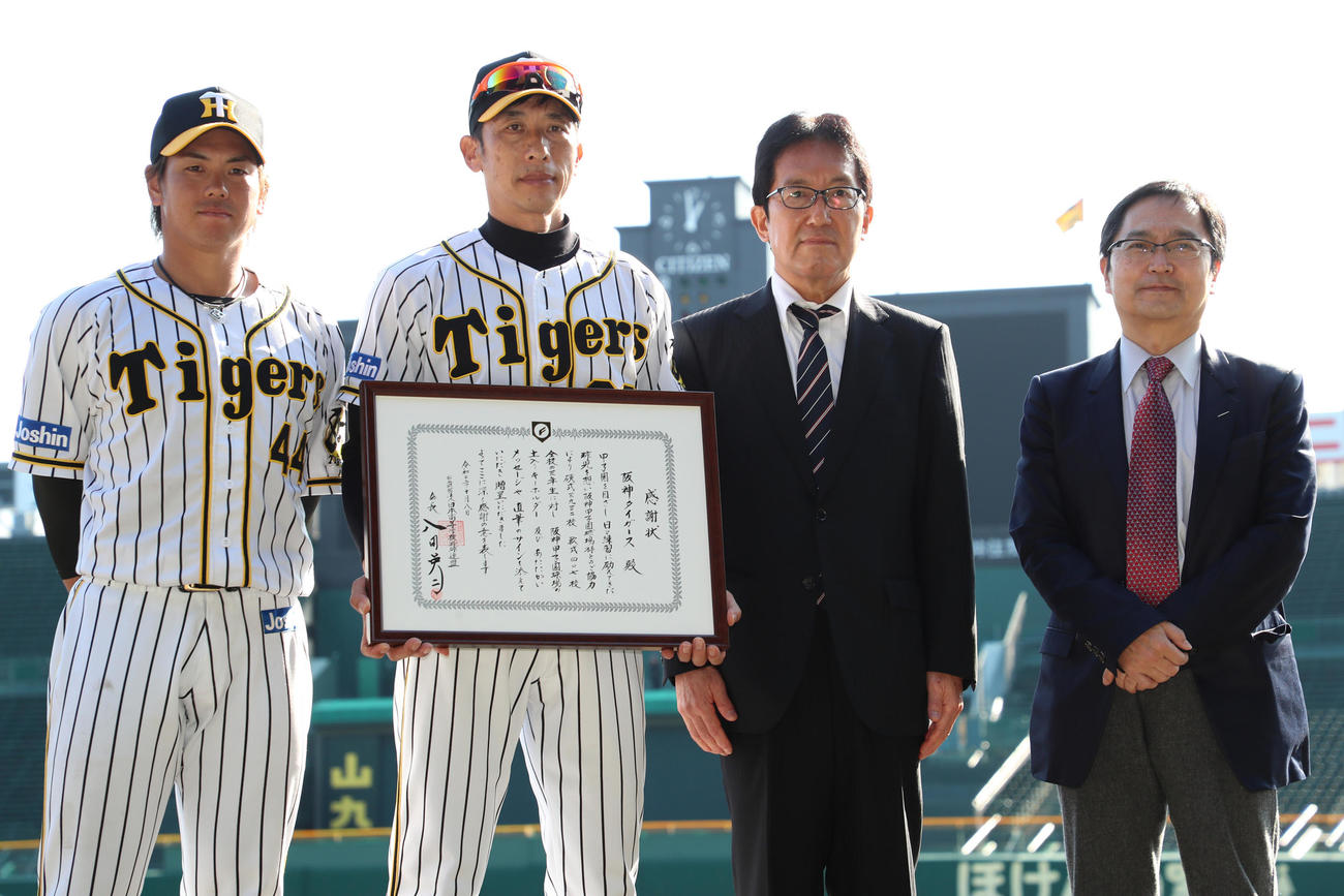日本高野連から感謝状を受け取る阪神矢野監督（左から2人目）、左から梅野、矢野監督、日本高野連の井上康雄副会長、氏家弘二副会長（撮影・清水貴仁）