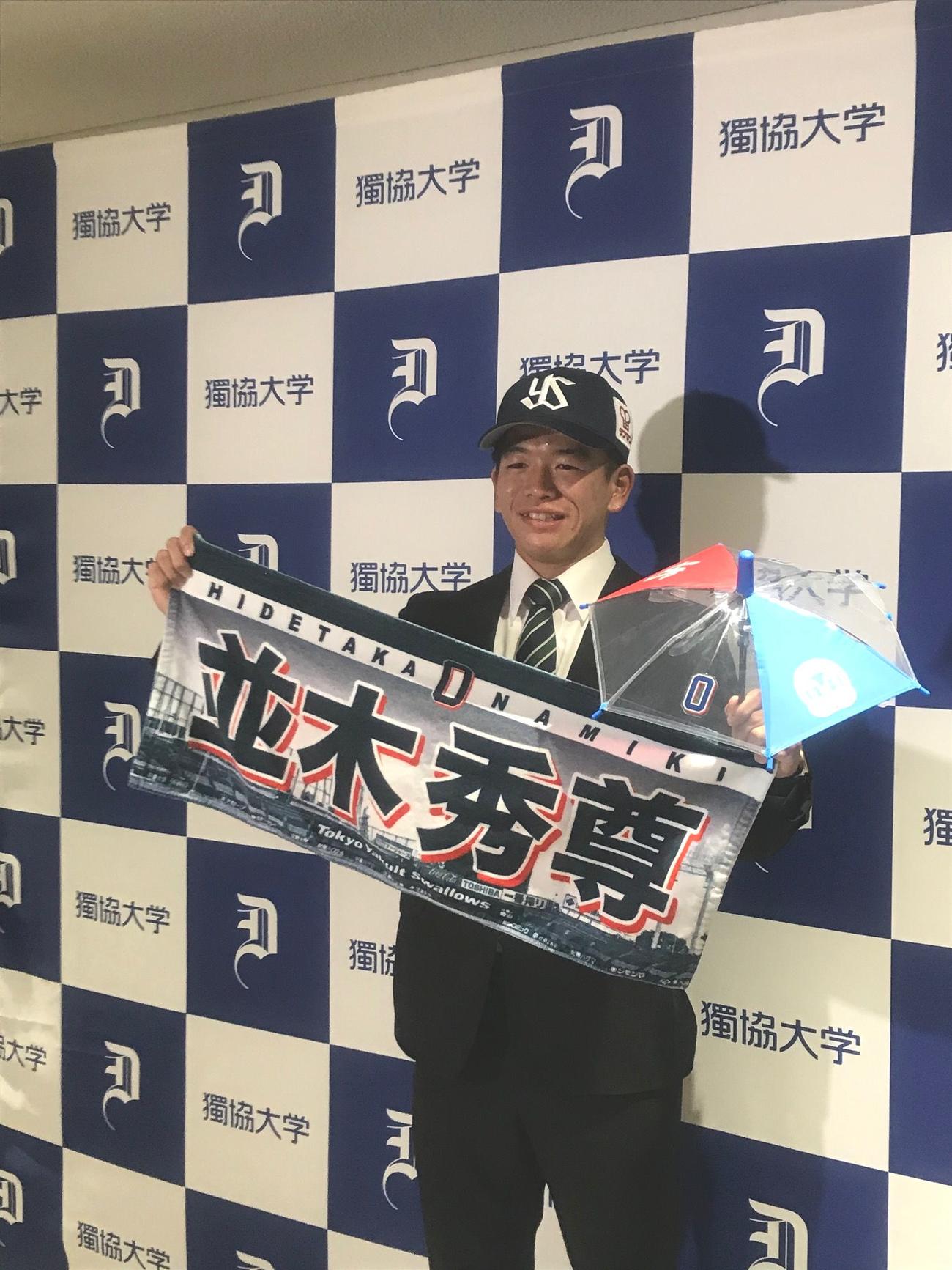 ヤクルトと仮契約を結び、グッズを手にするドラフト5位の独協大・並木（中央）