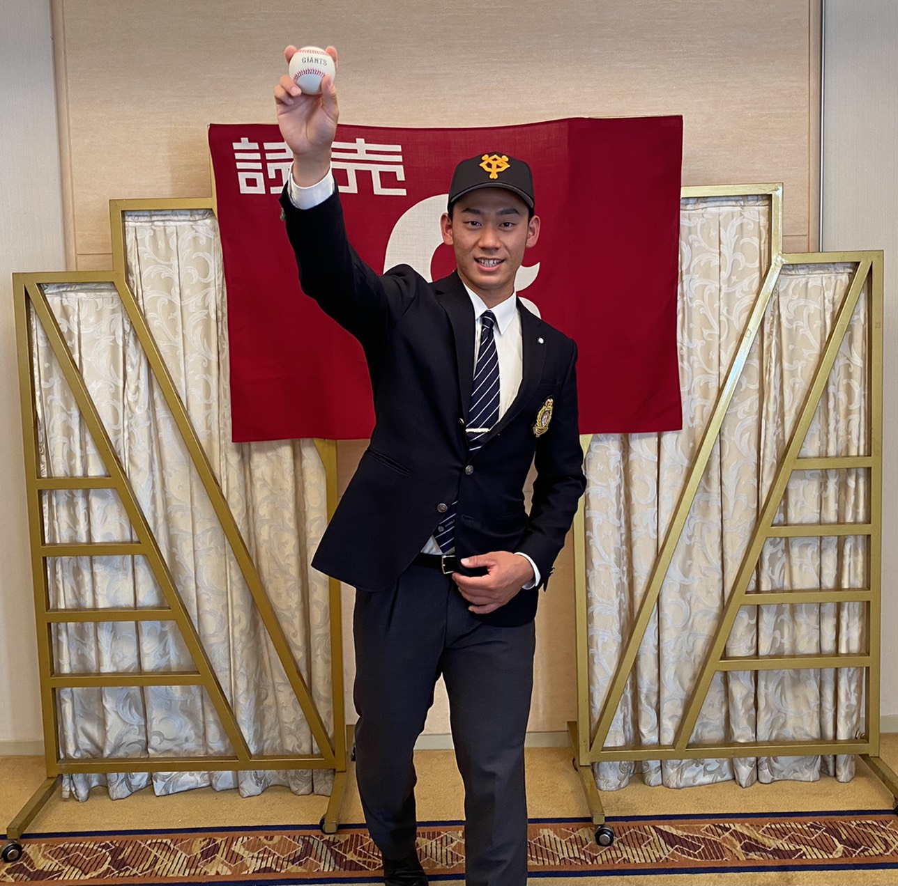 仮契約を結び、球団旗の前で投球フォームを見せる巨人育成9位の筑波大・奈良木（撮影・久永壮真）
