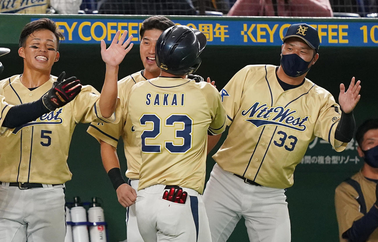 NTT西日本対Hоnda鈴鹿　3回表NTT西日本1死二塁、右越えに逆転の2点本塁打を放ち、ナインにタッチで迎えられるNTT西日本・酒井（中央）（撮影・菅敏）