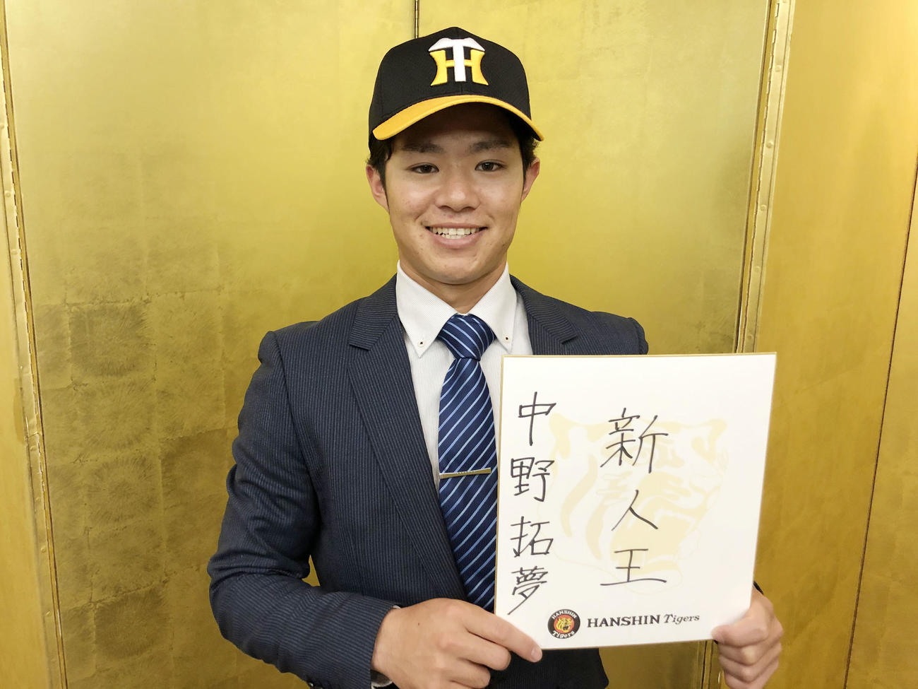 阪神と仮契約を結んだ中野は目標を書いた色紙を笑顔で見せる（球団提供）