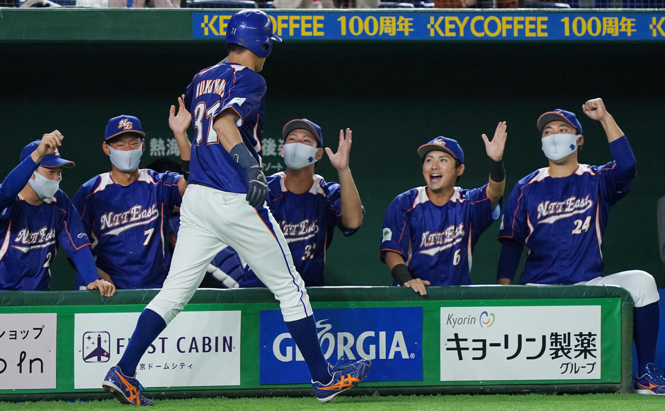 四国銀行対NTT東日本　1回裏NTT東日本無死三塁、打者・小林の内野ゴロの間に三塁から生還し、ナインにタッチで迎えられるNTT東日本・向山（撮影・菅敏）