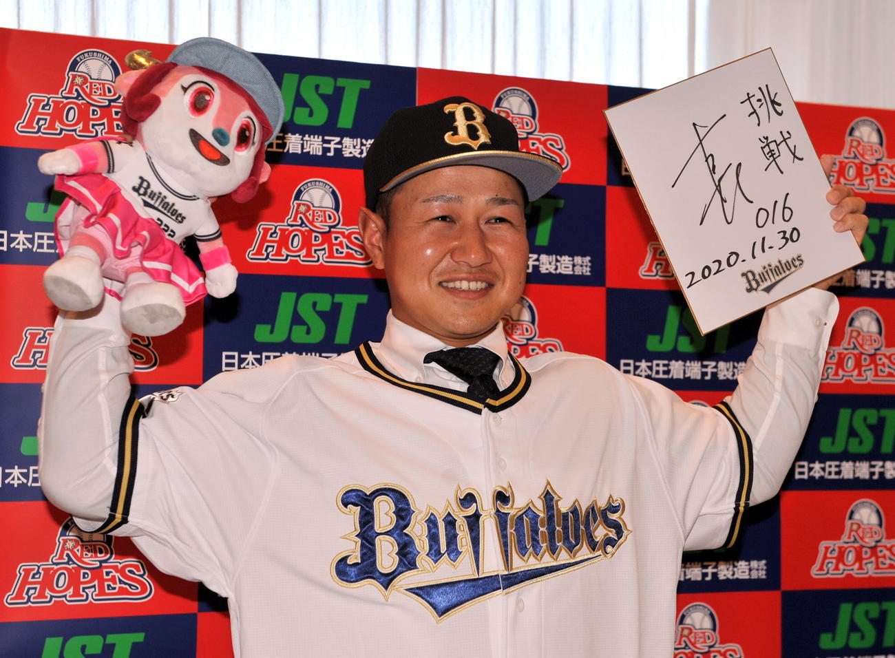 オリックスと仮契約した古長は球団マスコットと「挑戦」と書き込んだサイン色紙を手に、ユニホーム姿で活躍を誓う（撮影・佐々木雄高）