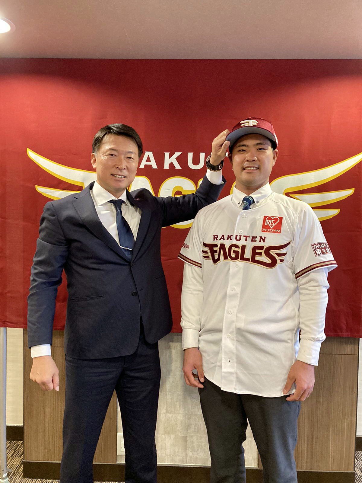 入団交渉を終え、笑顔を見せる楽天内間。左は沖原スカウト（楽天野球団提供）