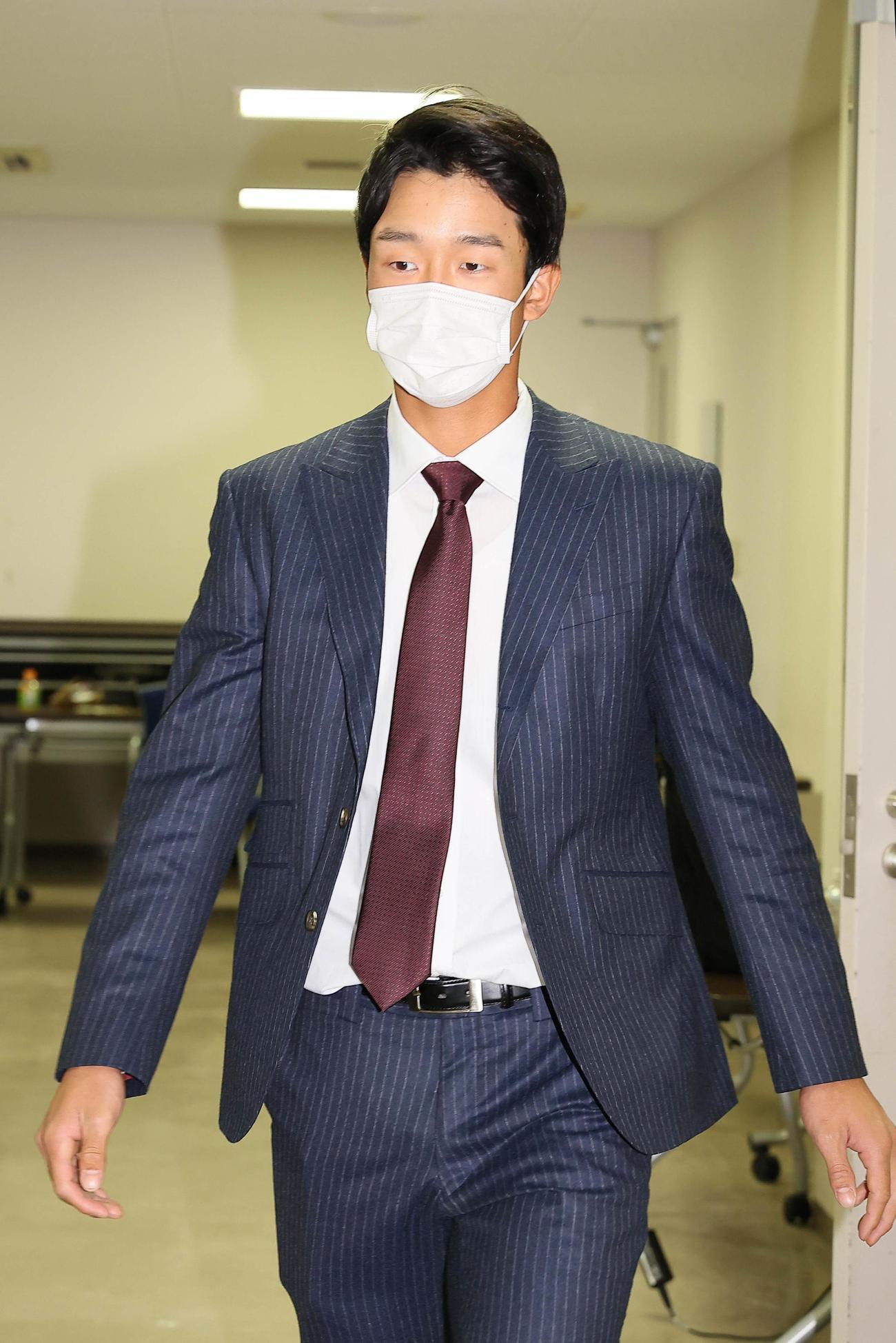 年俸1100万円で契約更改し、会見場入りをする小幡竜平　（カメラ・馬場　秀則）　