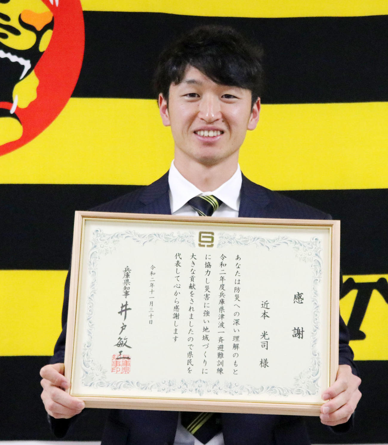 「兵庫県津波一斉避難訓練」の広報ポスターに起用され兵庫県知事から感謝状を受け取った近本（球団提供）